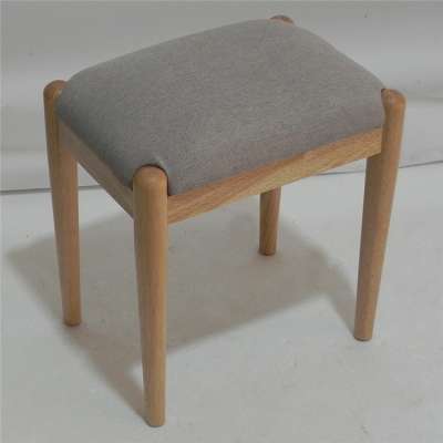 A four legged chair with sponge cushion and no back for home use